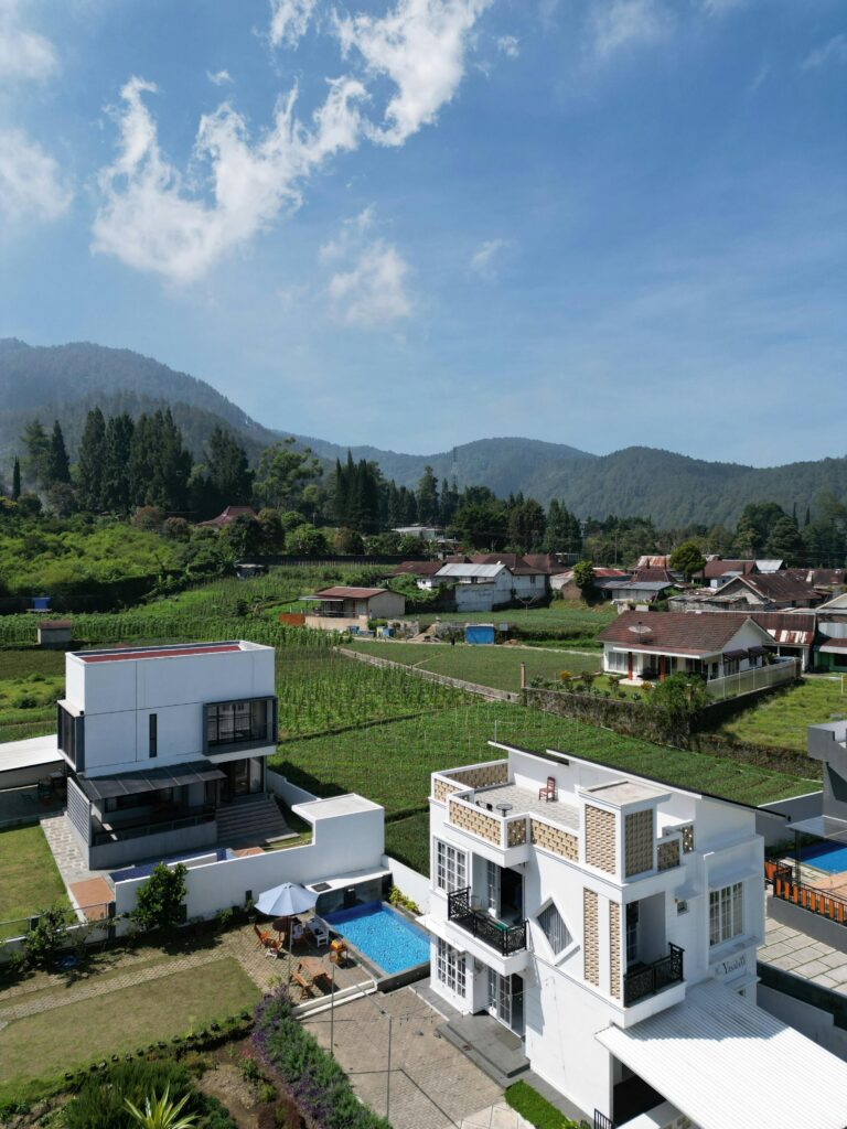 Modern villa with pool surrounded by lush green valley and mountains.